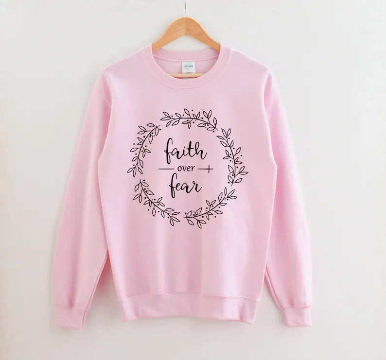 Faith Apparel pink cotton sweatshirt with inspirational 'Faith Over Fear' print. Perfect for Christian women's casual outfits.