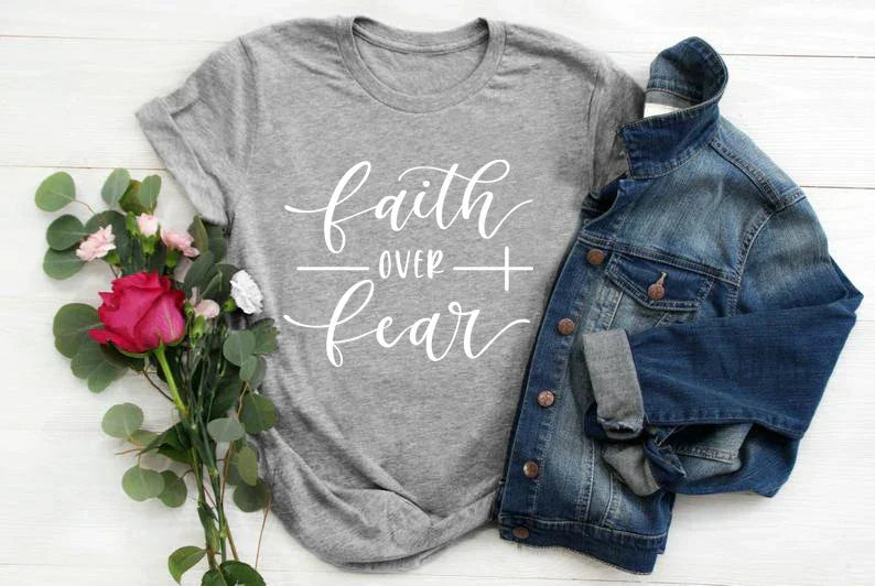 BC Faith Over Fear Christian T-Shirt in soft pink with black graphic slogan, styled with casual shoes, sunglasses, and roses for women’s fashion.