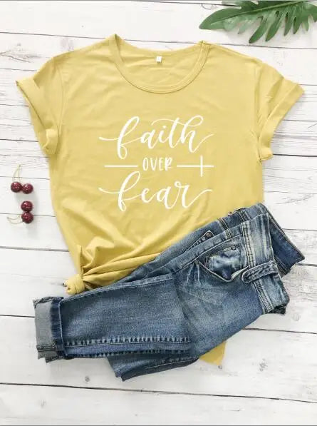 BC Faith Over Fear Christian T-Shirt in soft pink with black graphic slogan, styled with casual shoes, sunglasses, and roses for women’s fashion.