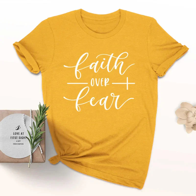 BC Faith Over Fear Christian T-Shirt in soft pink with black graphic slogan, styled with casual shoes, sunglasses, and roses for women’s fashion.