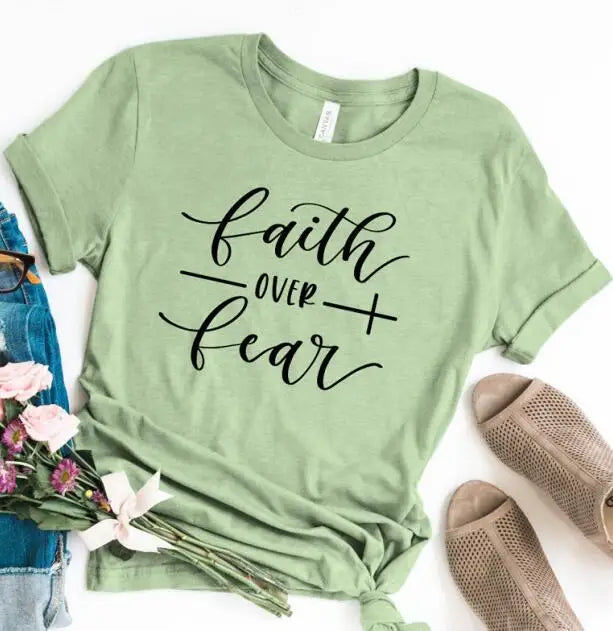 BC Faith Over Fear Christian T-Shirt in soft pink with black graphic slogan, styled with casual shoes, sunglasses, and roses for women’s fashion.