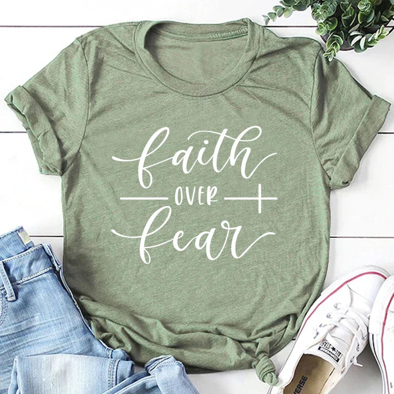BC Faith Over Fear Christian T-Shirt in soft pink with black graphic slogan, styled with casual shoes, sunglasses, and roses for women’s fashion.