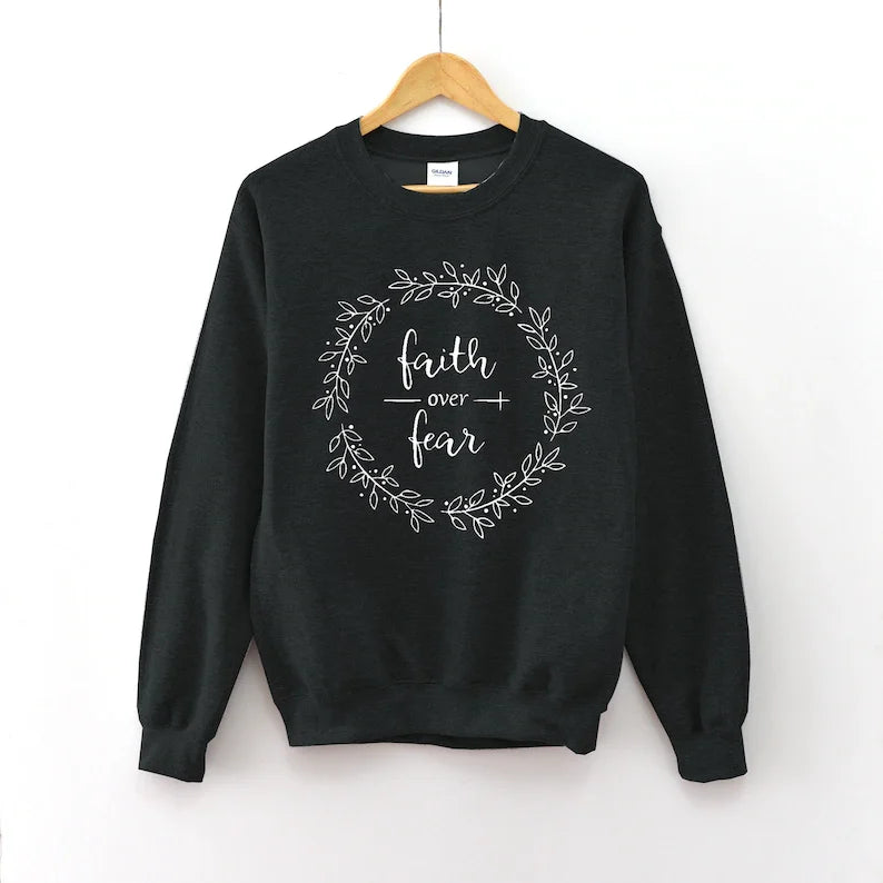 Faith Apparel black women's sweatshirt with white wreath and 'Faith Over Fear' text. Made of soft, breathable cotton.
