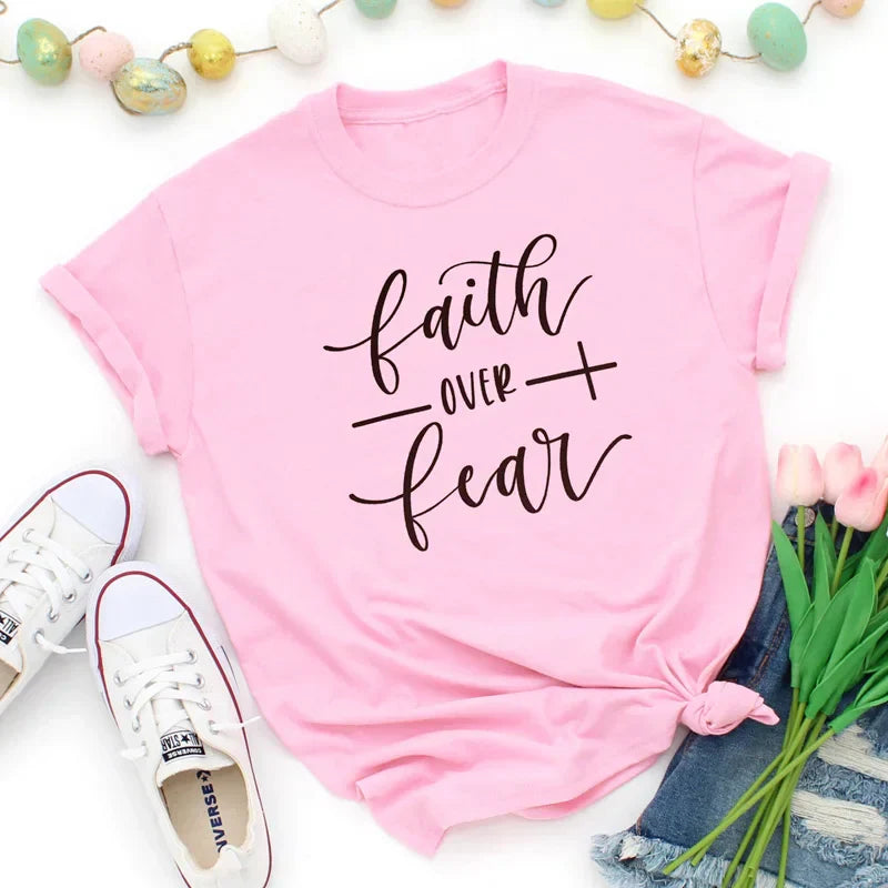 BC Faith Over Fear Christian T-Shirt in soft pink with black graphic slogan, styled with casual shoes, sunglasses, and roses for women’s fashion.
