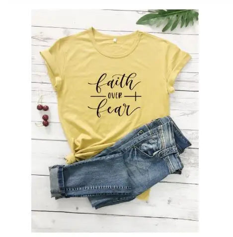 BC Faith Over Fear Christian T-Shirt in soft pink with black graphic slogan, styled with casual shoes, sunglasses, and roses for women’s fashion.