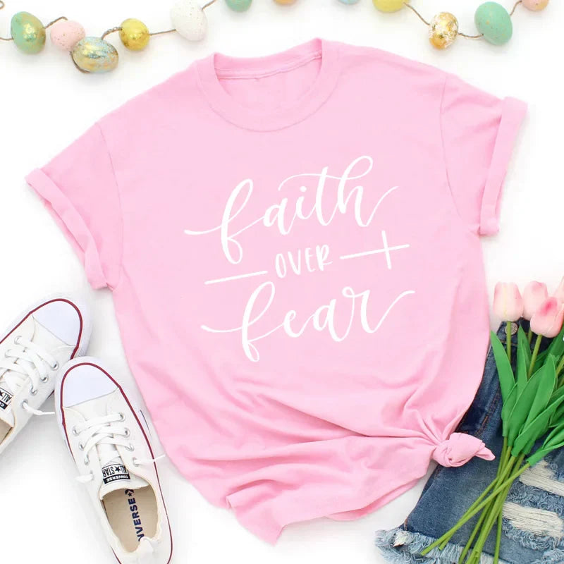 BC Faith Over Fear Christian T-Shirt in soft pink with black graphic slogan, styled with casual shoes, sunglasses, and roses for women’s fashion.